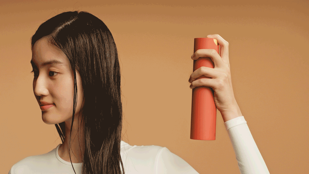 Modelka używająca odżywki w sprayu bez spłukiwania Dyson Omega