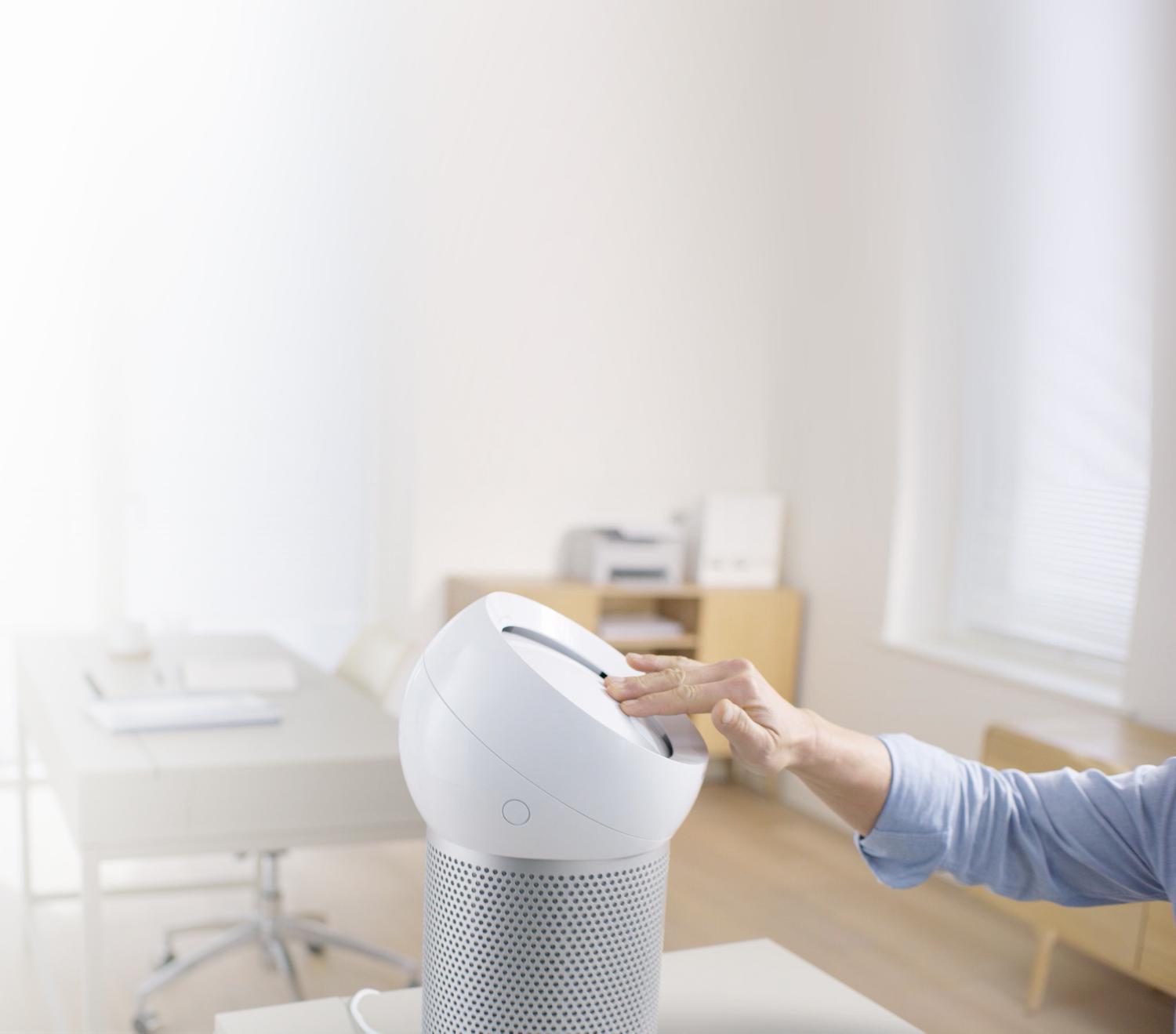 Hand reaches out to refocus airflow on the Dyson Pure Cool Me personal purifying fan