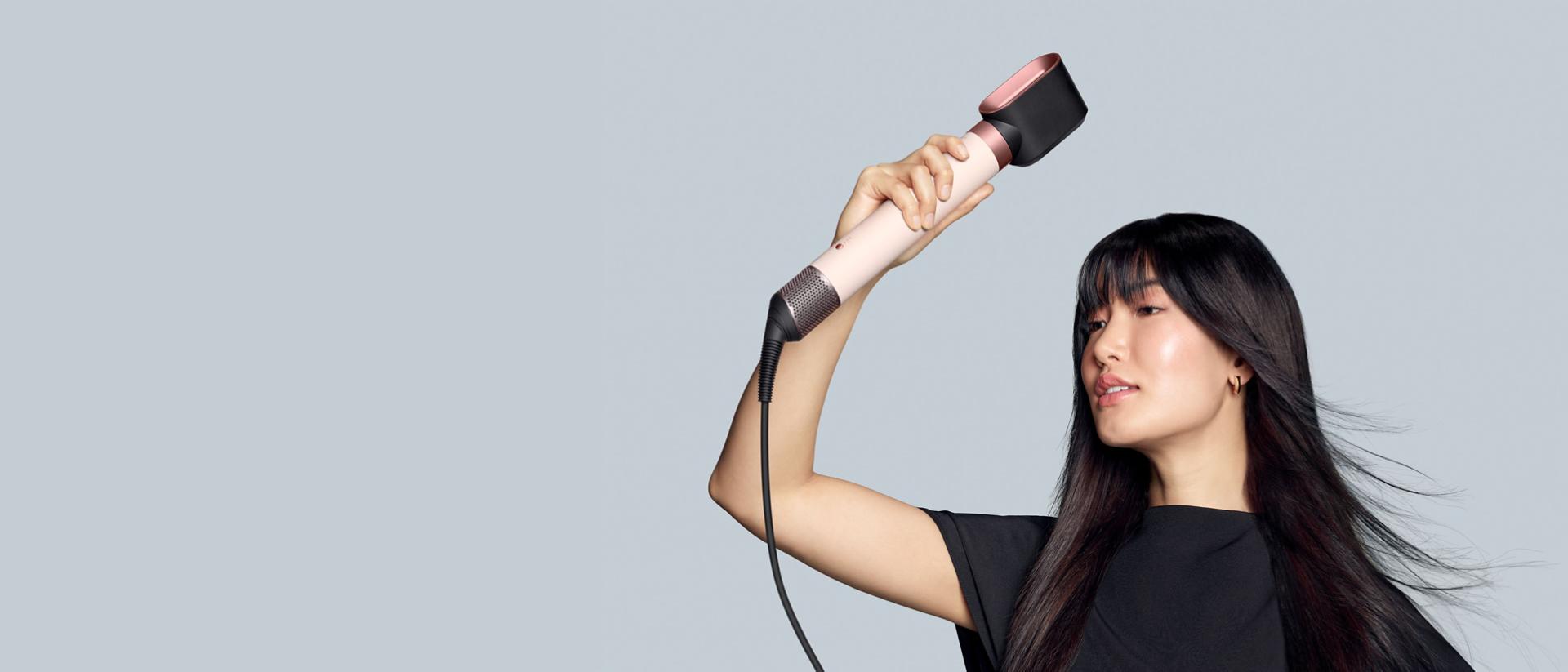 The Dyson Airwrap Co-anda2x multi-styler in use with a model.