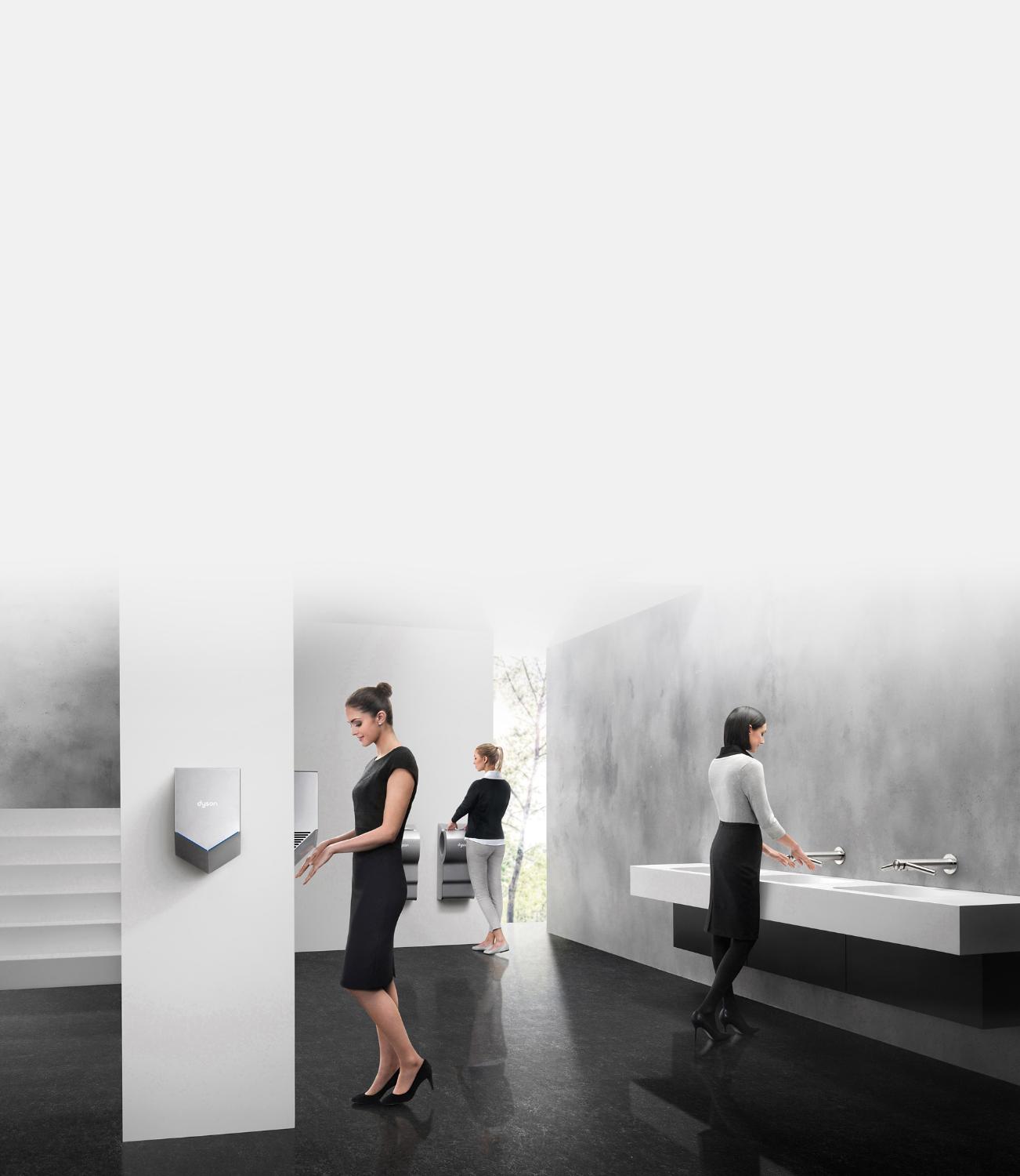 Femmes dans les toilettes utilisant les sèche-mains Dyson Airblade