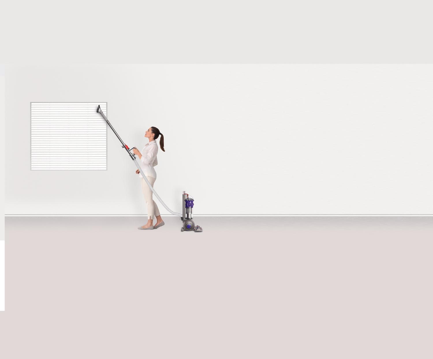Femme utilisant le tube-rallonge sur des stores.