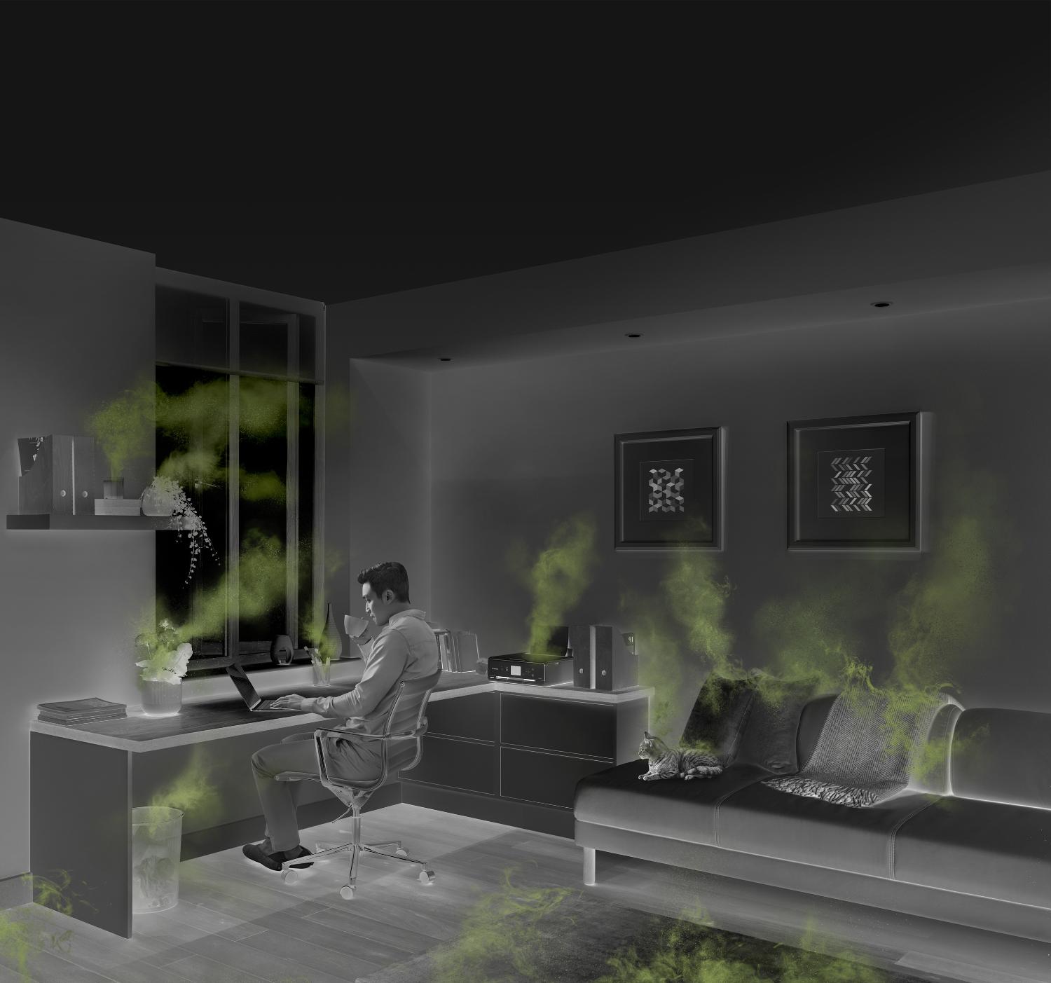 Man working in a home office, surrounded by sources of indoor air pollution