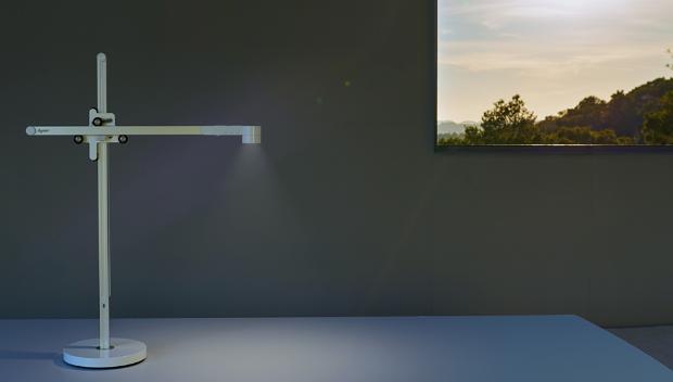 وحدة الإضاءة المكتبية Dyson Lightcycle داخل مبنى، مع نافذة يظهر من خلالها مشهد الغسق بالخارج