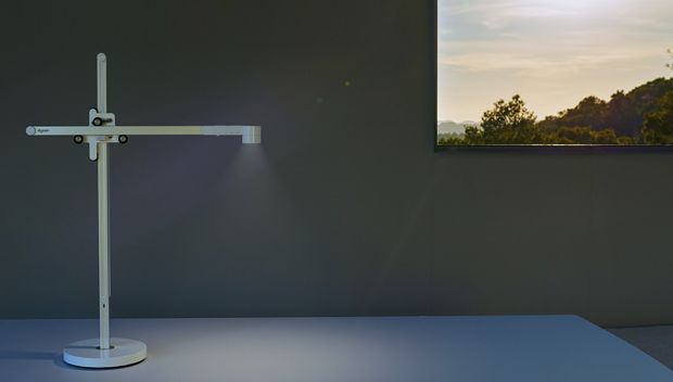 وحدة الإضاءة المكتبية Dyson Lightcycle داخل مبنى، مع نافذة يظهر من خلالها مشهد الغسق بالخارج