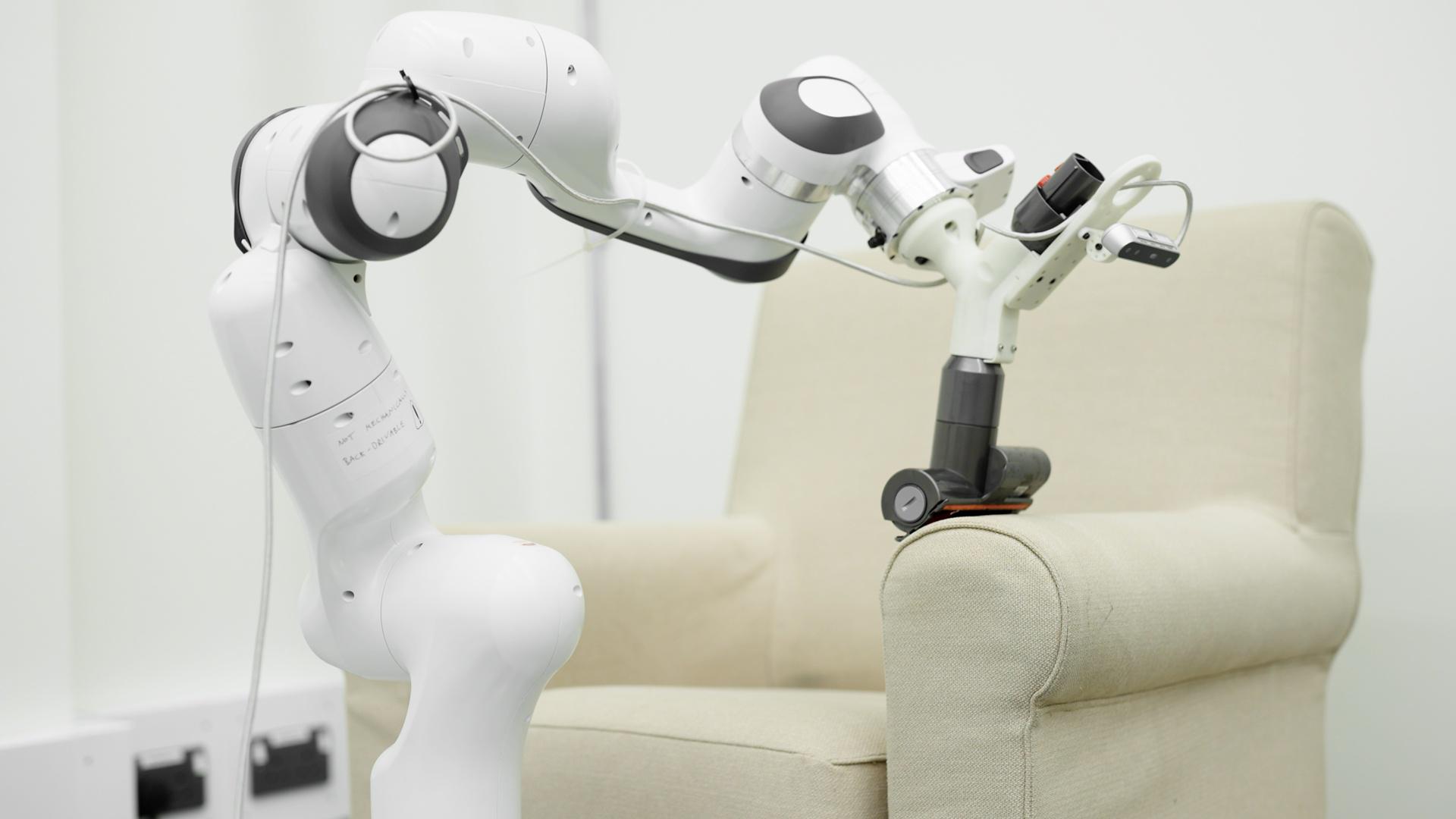 A robotic arm vacuuming a sofa