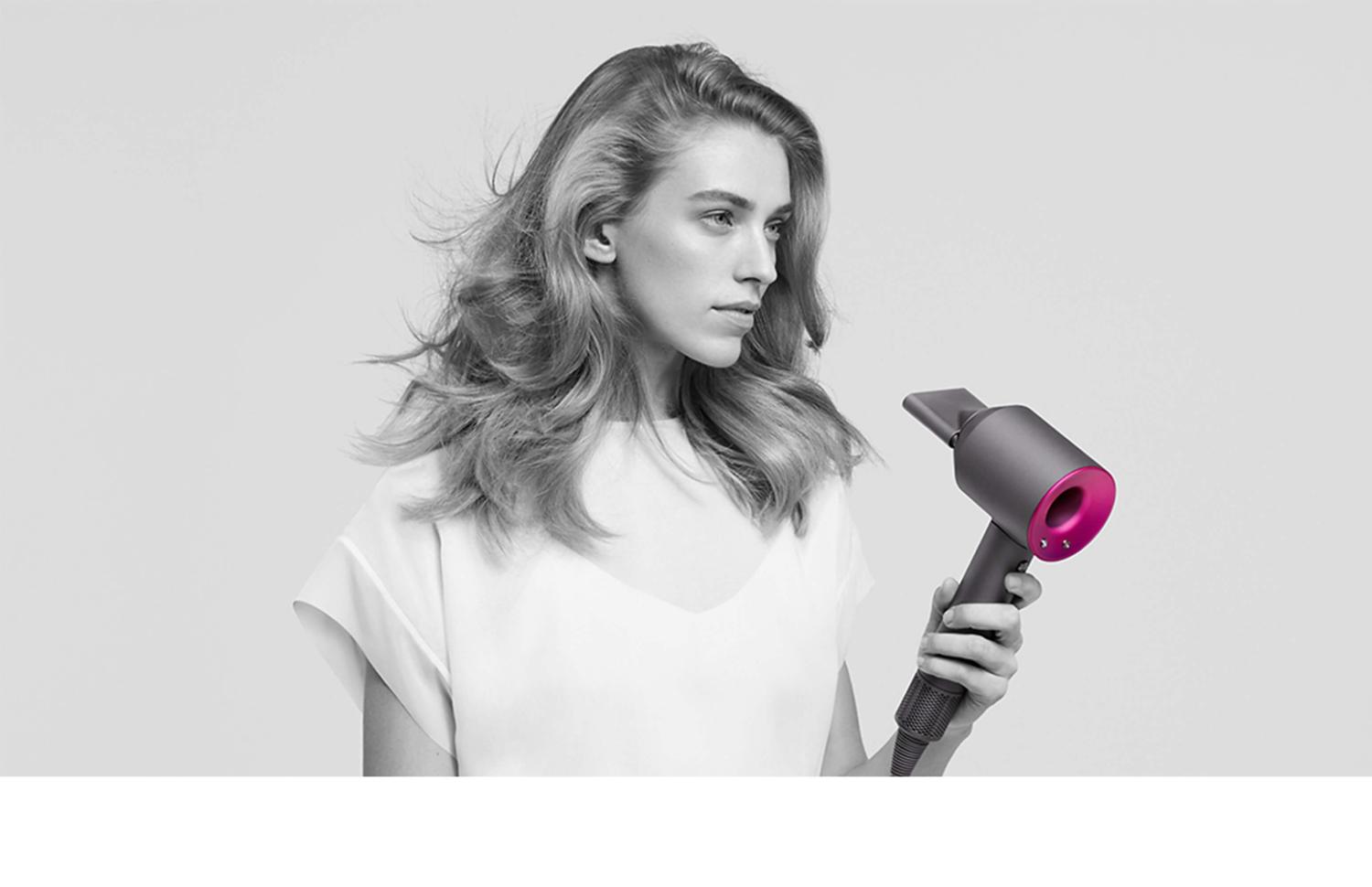 Modella che utilizza l'asciugacapelli Dyson Supersonic™