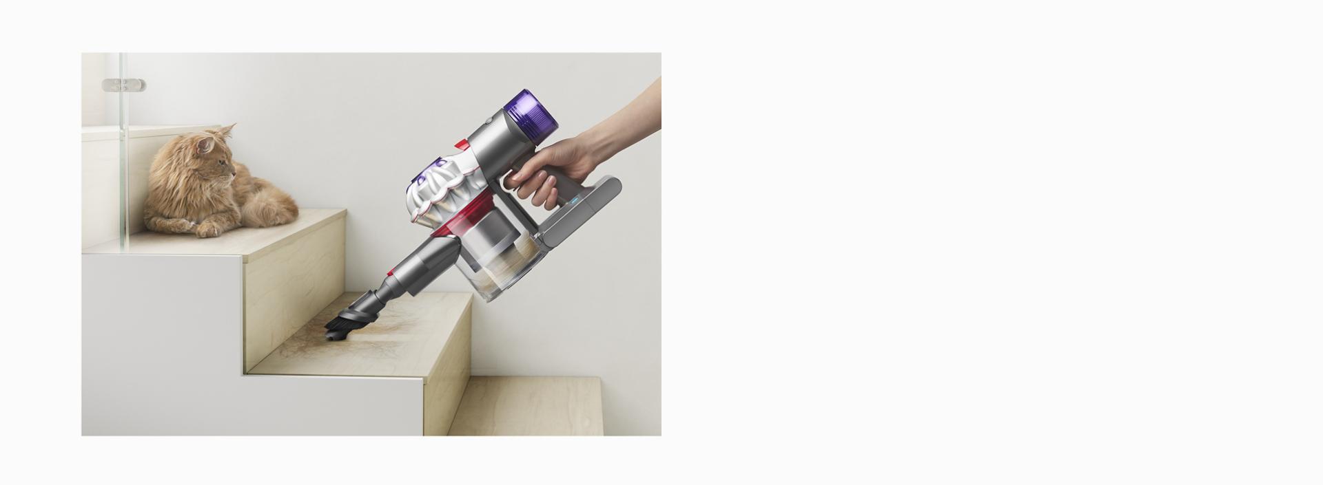 Dyson V8 vacuum being used as a handheld to clean stairs