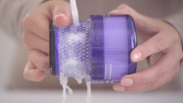 Filter being rinsed under running water.