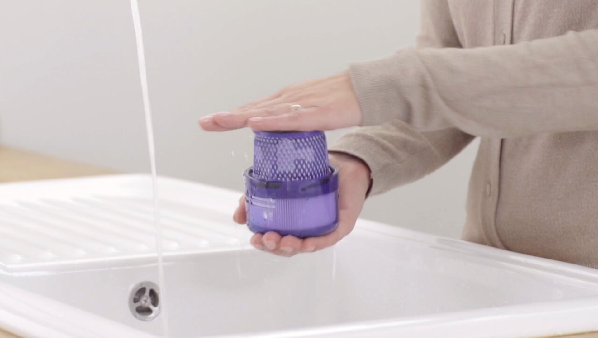 Filter held in two hands over a sink.