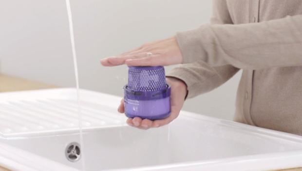 Filter held in two hands over a sink.