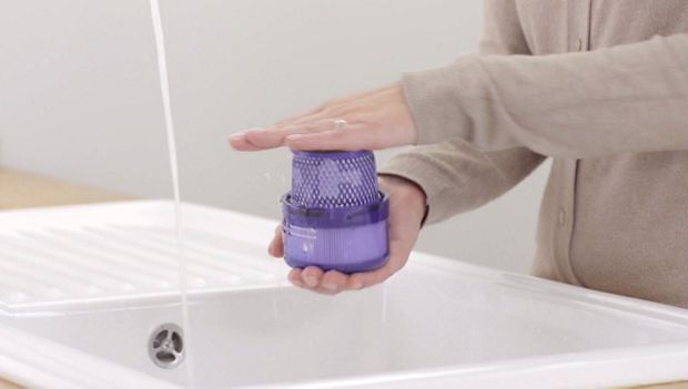 Filter held in two hands over a sink.