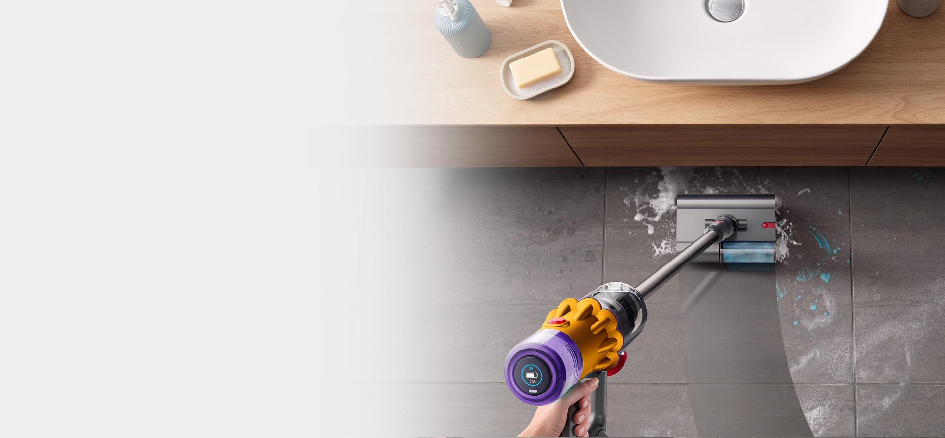 Dyson V12s Detect Slim Submarine wet cleaner head tackling a tough stain on a kitchen floor.