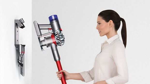 Woman placing Dyson V7 vacuum back ino storage dock