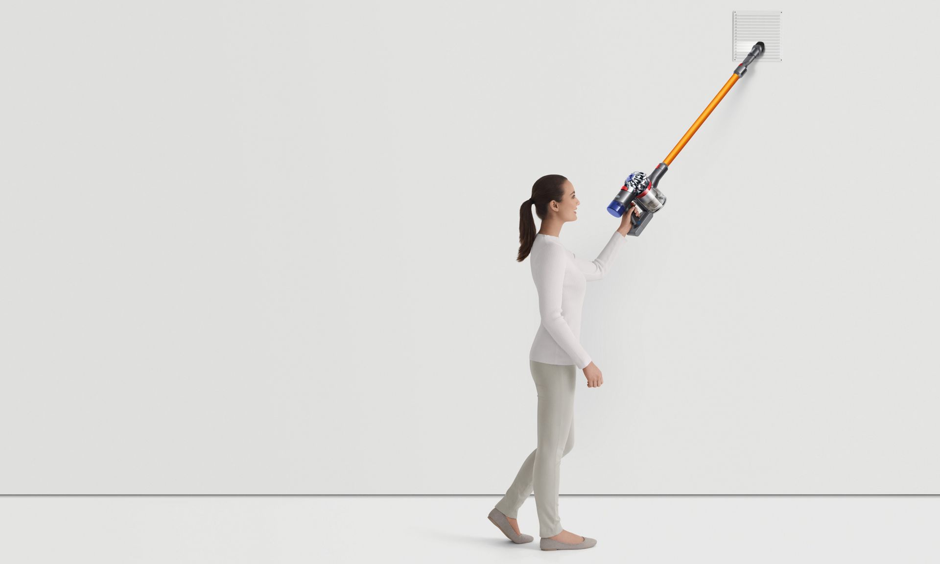 Woman cleaning with the Dyson V8 vacuum cleaner in a variety of scenarios 