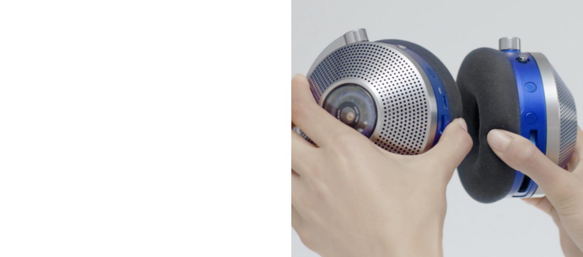 Hands holding the ear cups of the Dyson Zone air-purifying headphones.