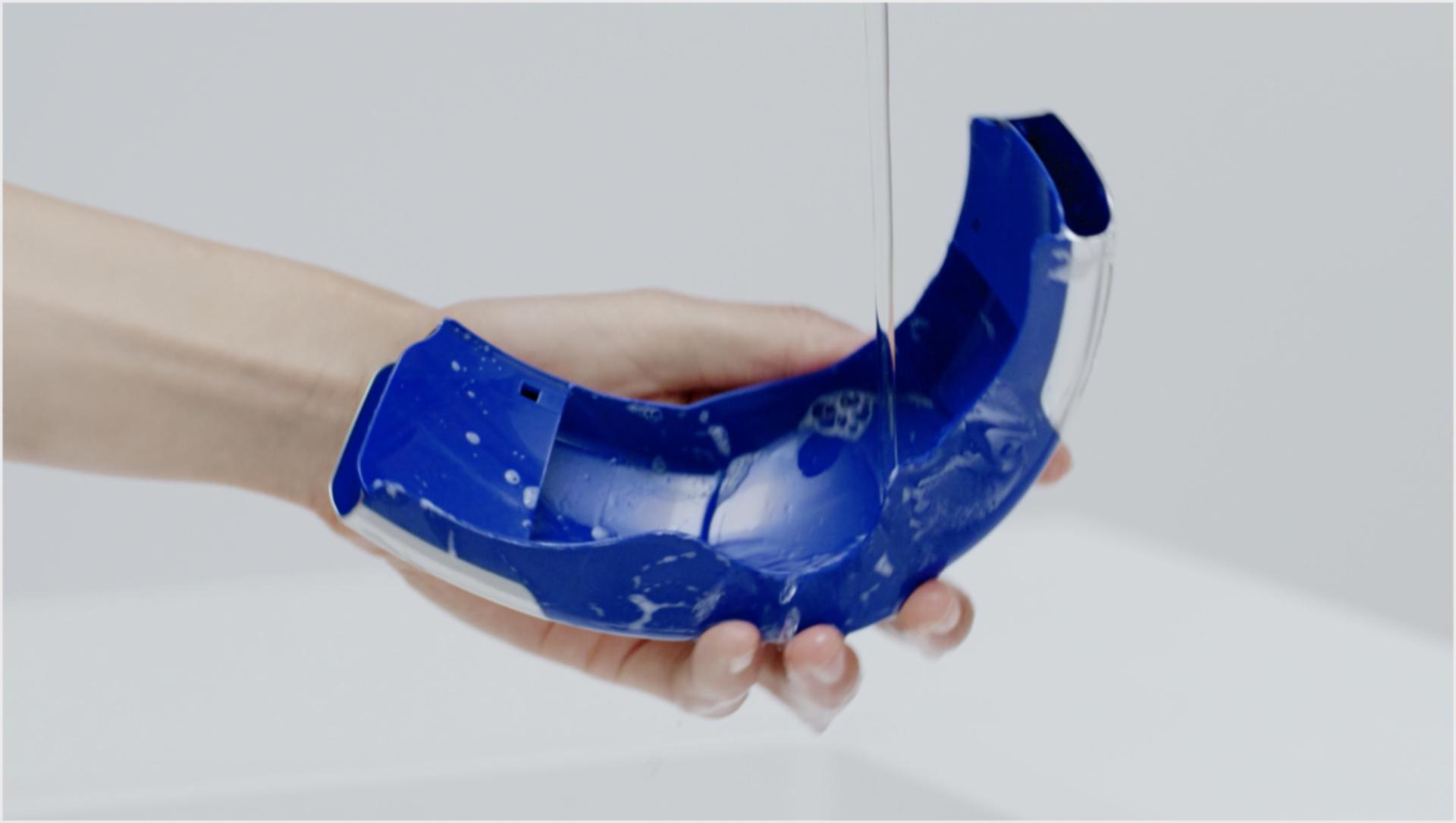 Cleaning the visor under a tap.