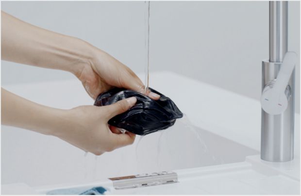 Cleaning the Community face covering with warm, soapy water.