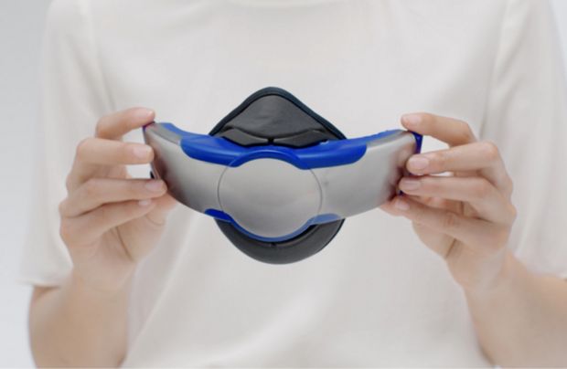 A woman holds the visor with the Community face covering attached.