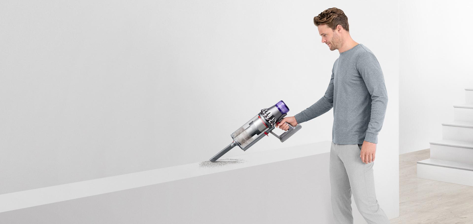 Man vacuuming a shelf with the Dyson Outsize vacuum.