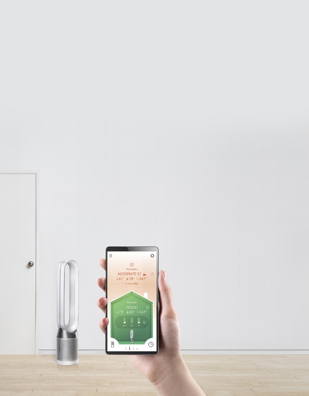 Woman holding a phone that shows the Dyson Link app which is used to control and monitor home air quality