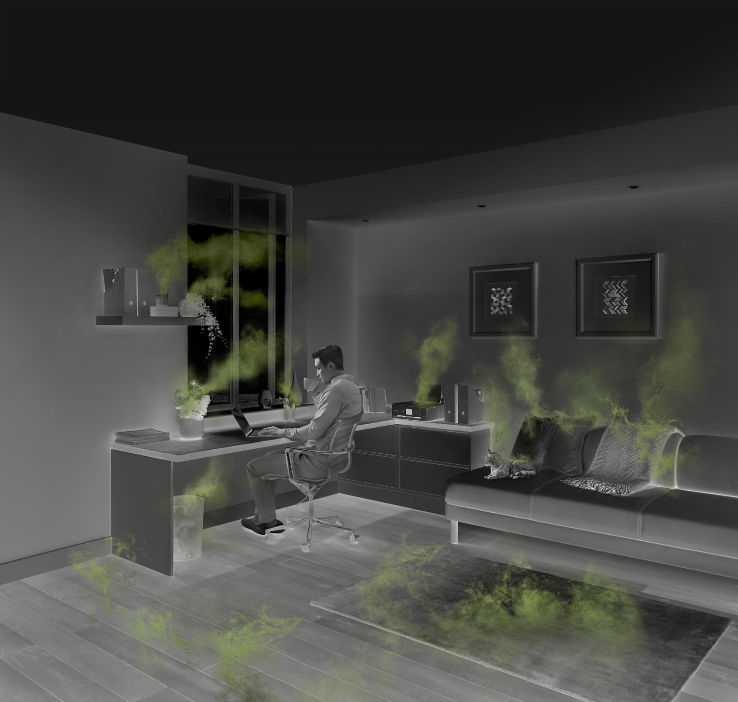 Man working in a home office, surrounded by sources of indoor air pollution