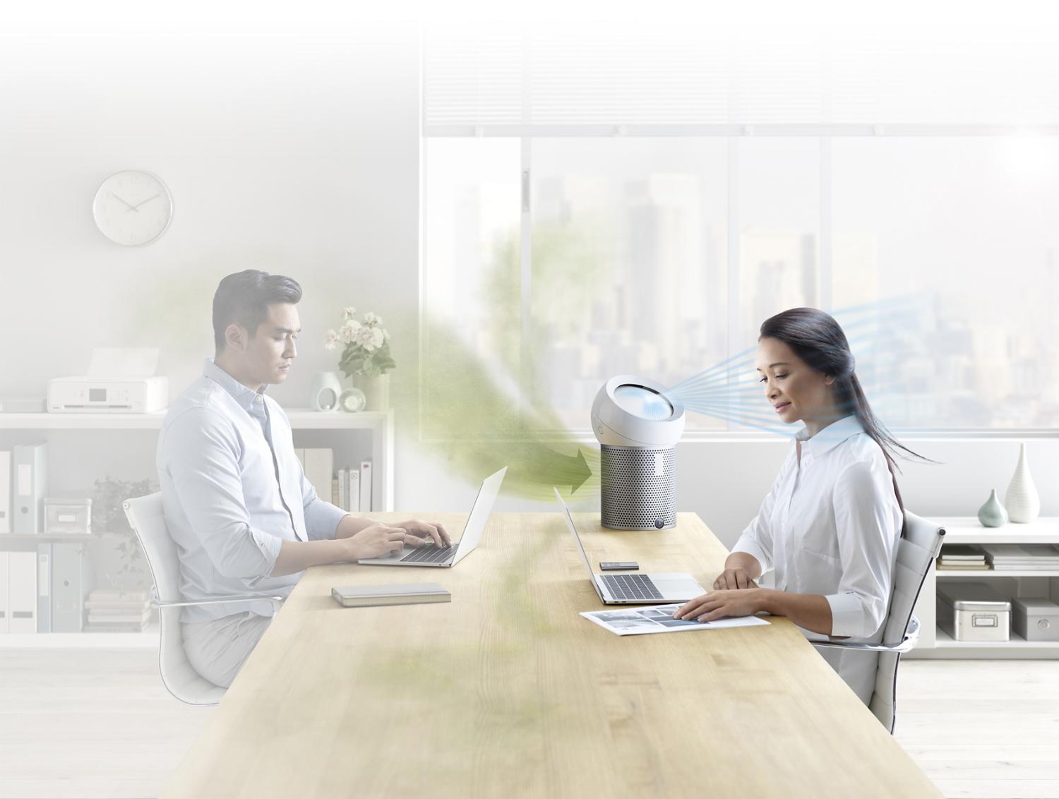 An office worker using a Dyson Pure Cool Me personal purifier fan