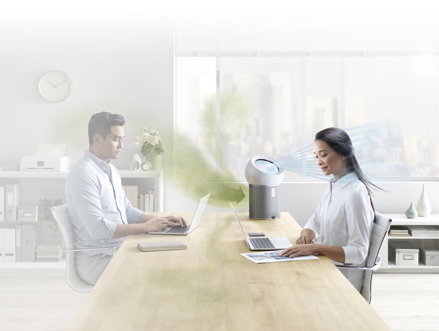 An office worker using a Dyson Pure Cool Me personal purifier fan