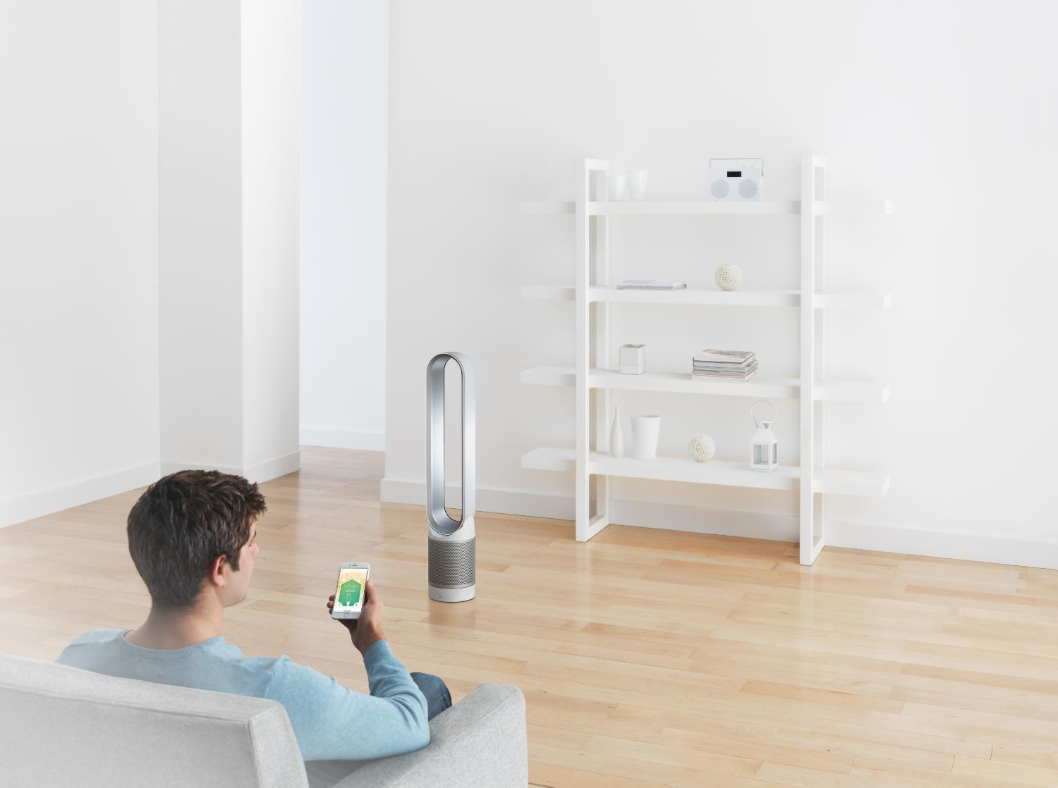 Man with smartphone and Dyson Pure Cool™ Link tower purifier