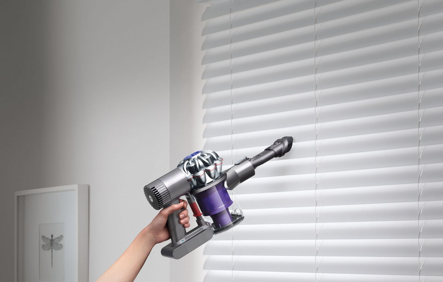  Dyson V6™ handheld vacuum on window blinds