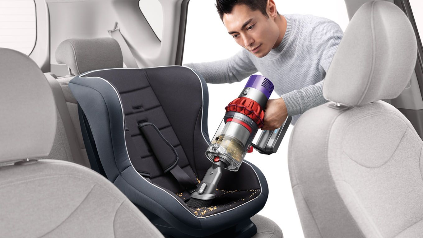Dyson Cyclone V10™ vacuum in handheld mode cleaning car seat Dyson Cyclone V10™ vacuum in handheld mode cleaning car seat