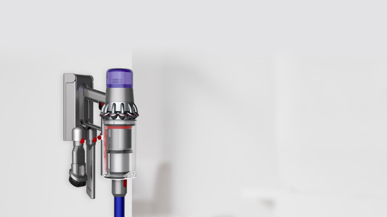 Person attaching their Dyson V11 into the wall docking station