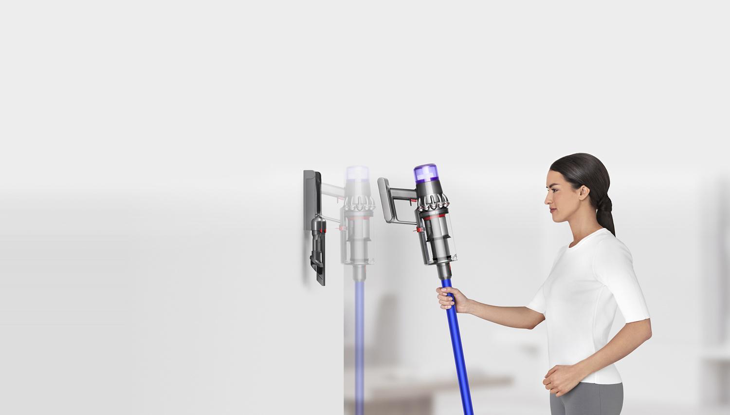 Woman placing Dyson V11™ vacuum into wall charging dock