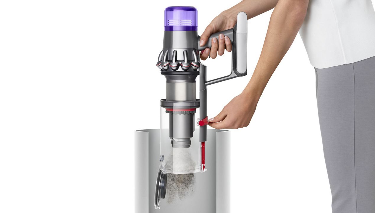 Woman emptying Dyson V11™ vacuum into bin