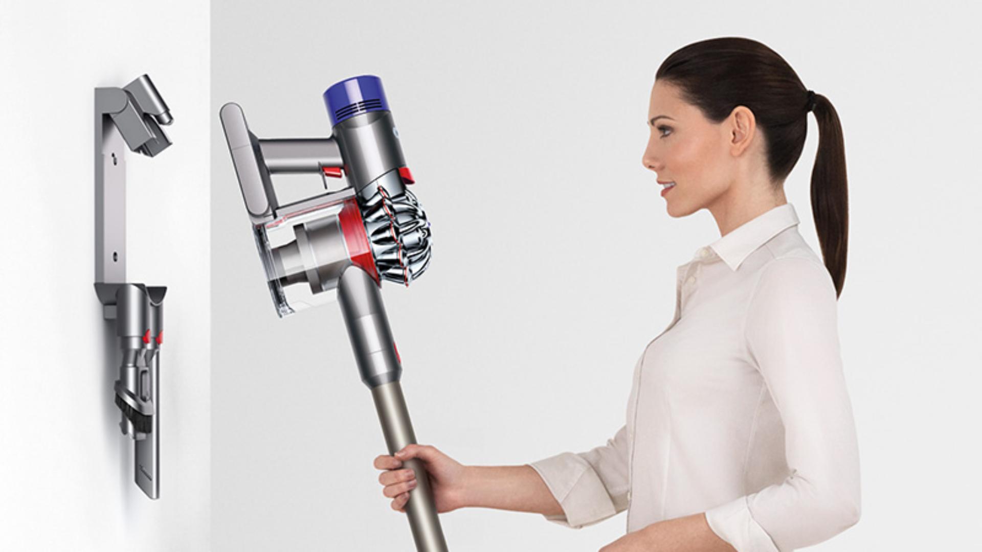 Woman using Dyson V8 Absolute vacuum docking station