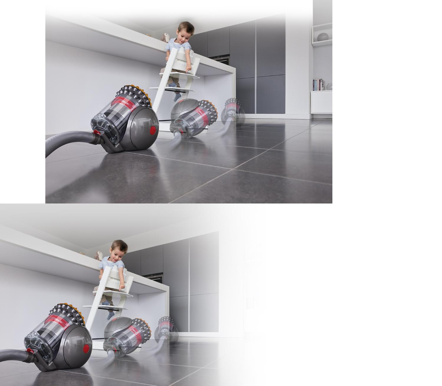 Kleinkind schaut zu, wie sich ein Dyson Big Ball Staubsauger automatisch wieder aufrichtet.