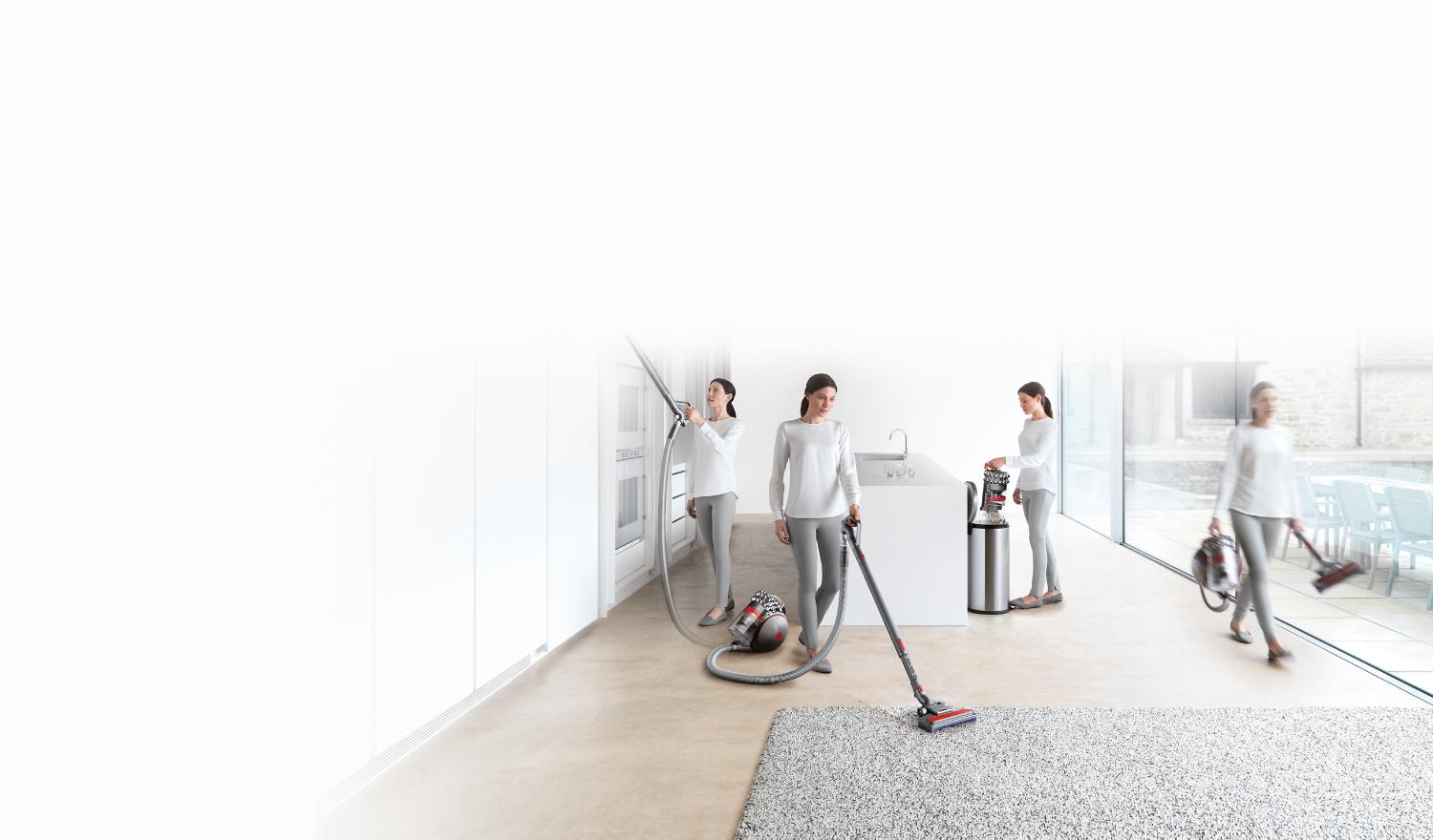Modell verwendet einen Dyson Bodenstaubsauger beim Reinigen höhergelegener Stellen, beim Reinigen eines Teppichs und beim Ausleeren des Staubsaugerbehälters in einen Mülleimer.