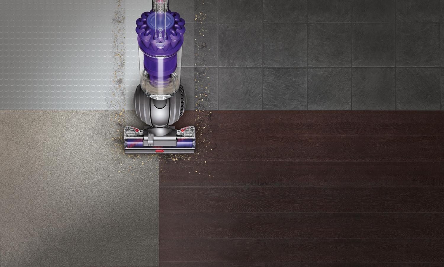 Dyson ball upright vacuum cleaner picking up debris across different floor types