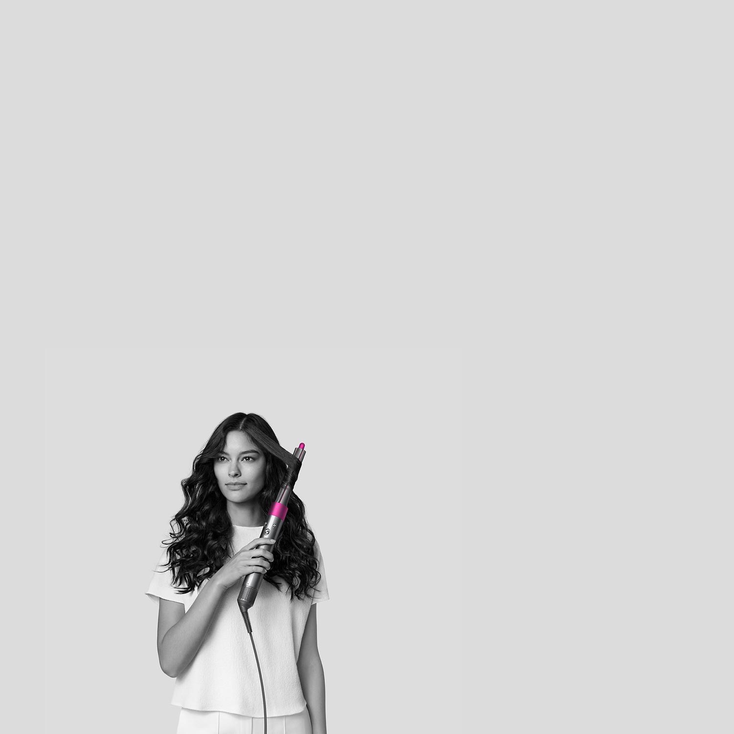 Woman styling hair with Dyson Airwrap styler.