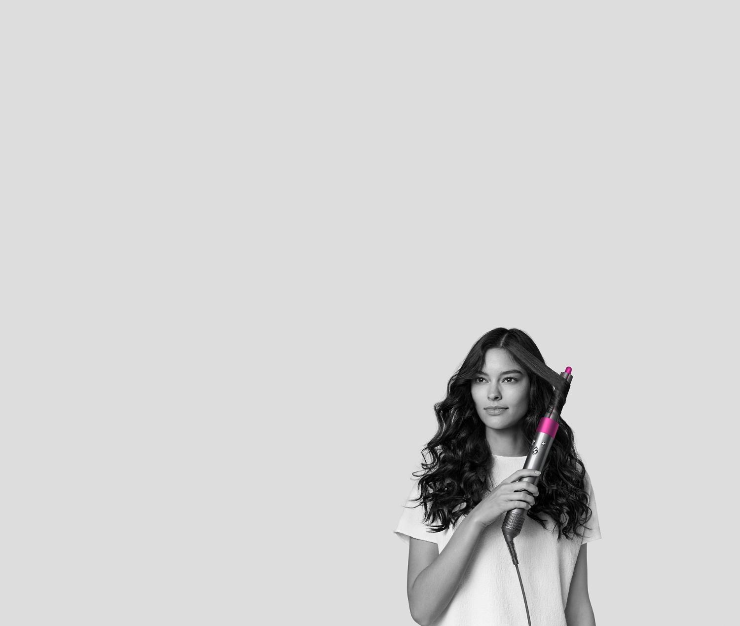 Donna che si arriccia i capelli con lo styler Dyson Airwrap