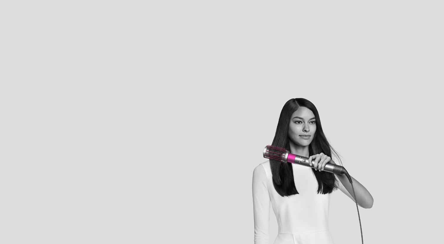 Woman using Dyson Airwrap smoothing brush