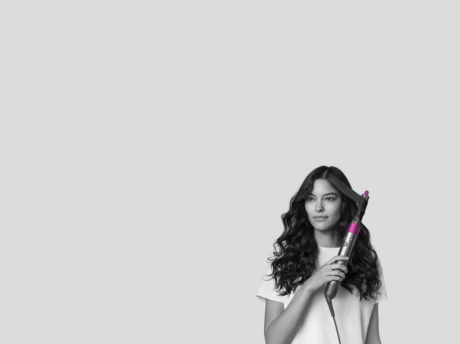 Mujer usando el moldeador Dyson Airwrap para rizar el cabello.