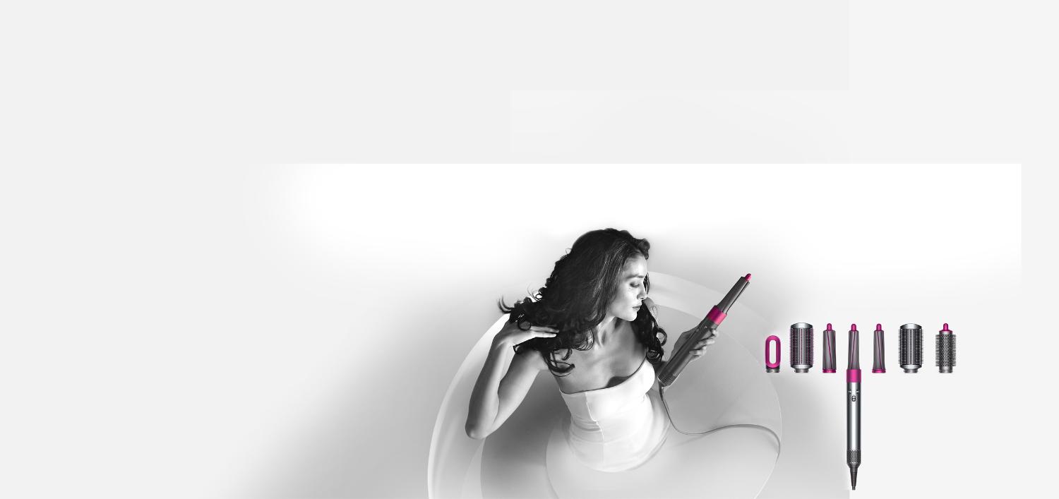 Woman holding the Dyson Airwrap™ styler next to attachments