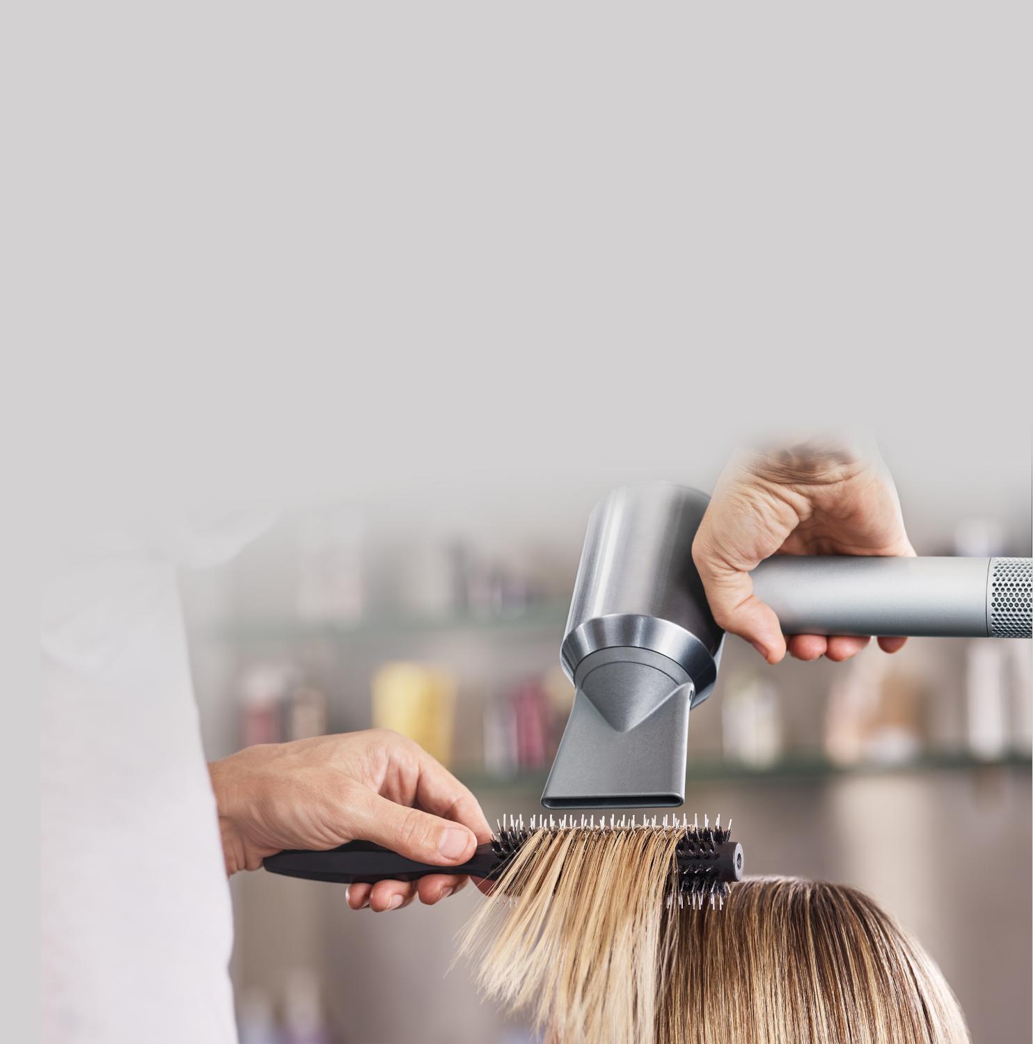 Dyson supersonic hair dryer being used to style hair