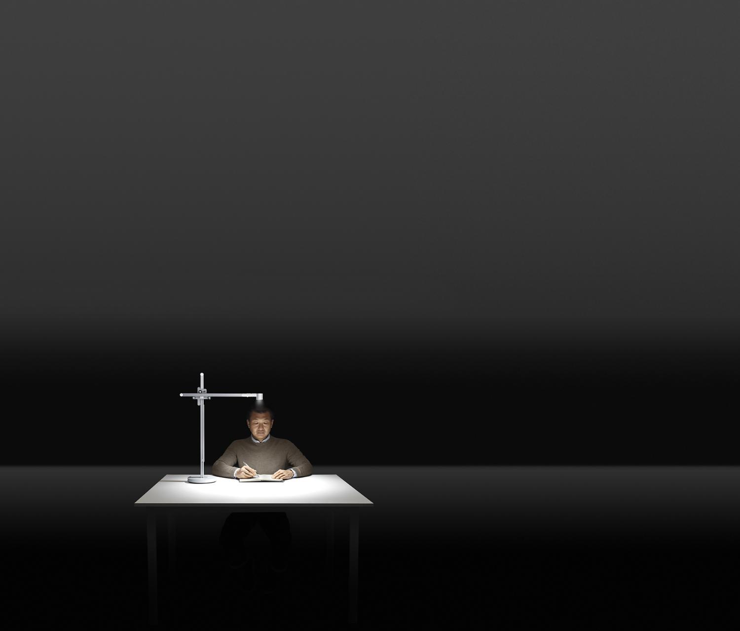 A middle-aged man reads under powerful light