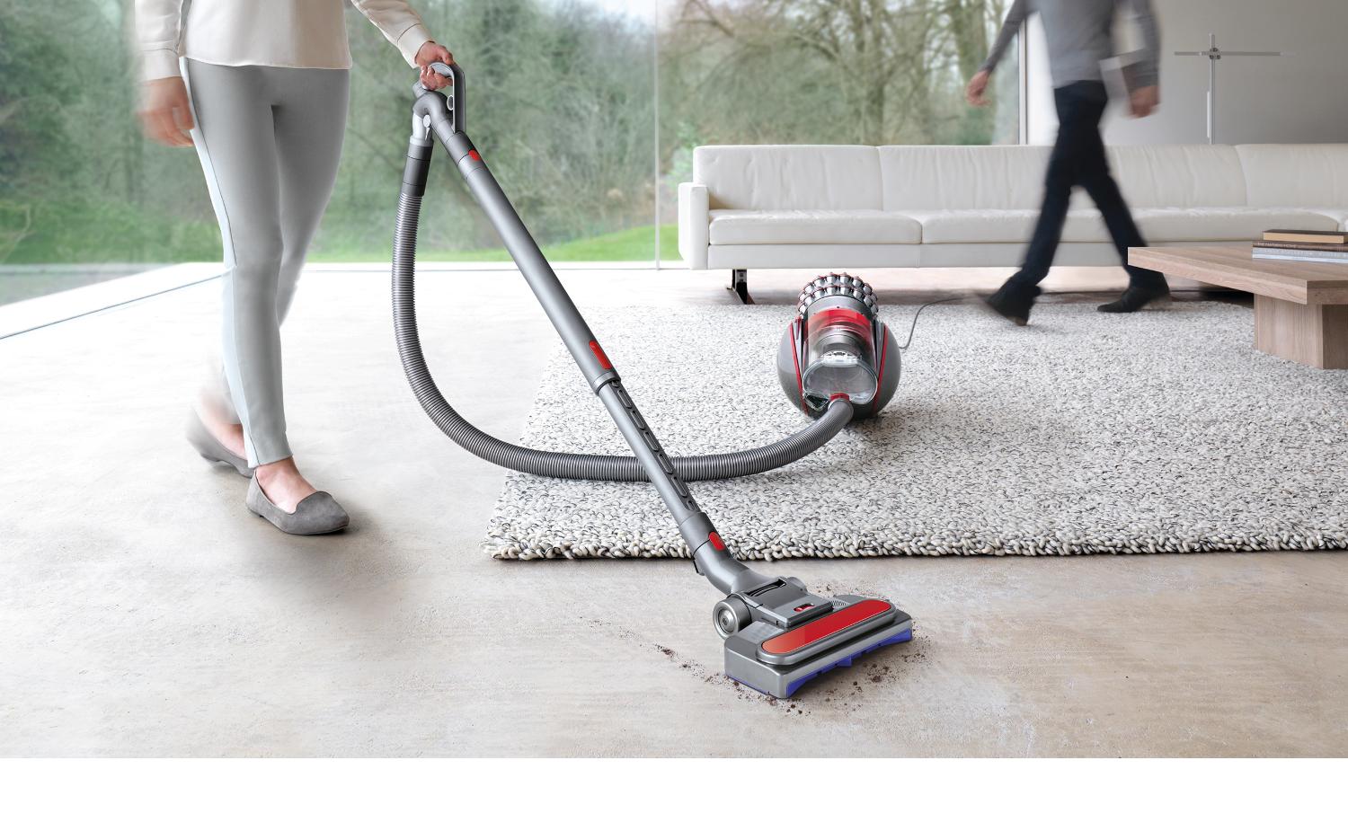 Model dat een Dyson Cinetic Big Ball gebruikt voor het reinigen van een harde vloer in een woonkamer.