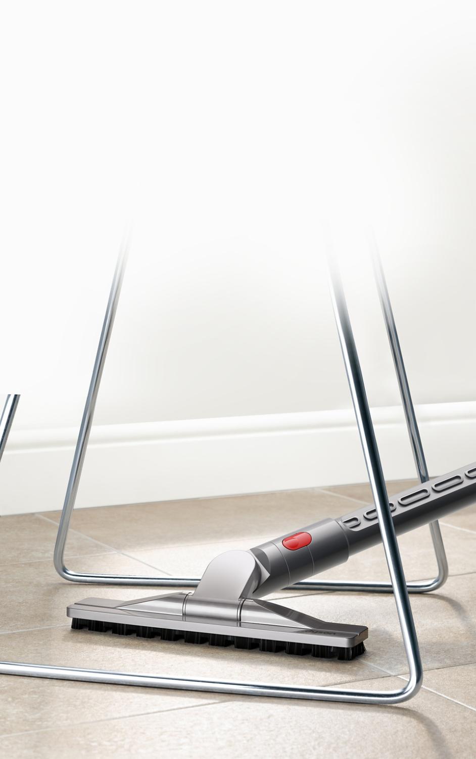 Articulating hard floor tool beneath chair