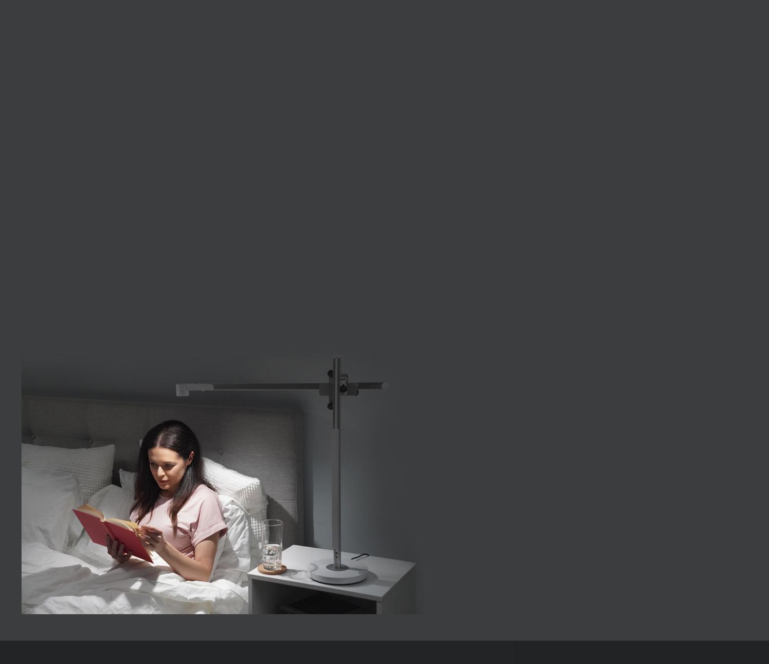 A woman drinks tea in bed in relaxing light
