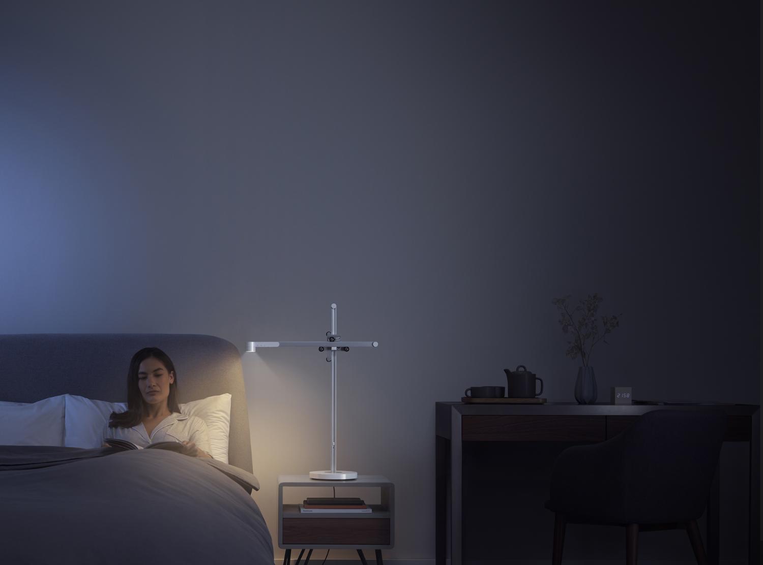 A woman drinks tea in bed in relaxing light