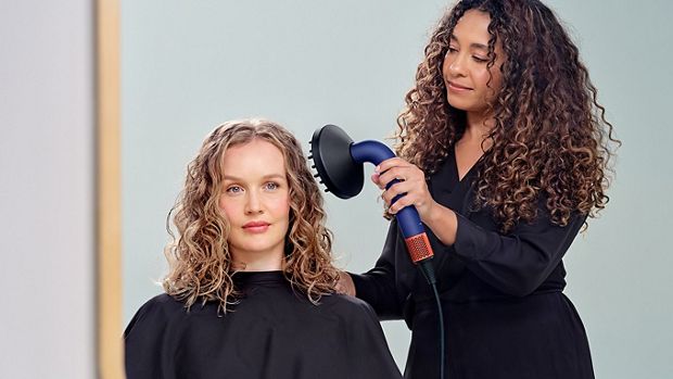 Modelka susząca włosy suszarką Dyson Supersonic r