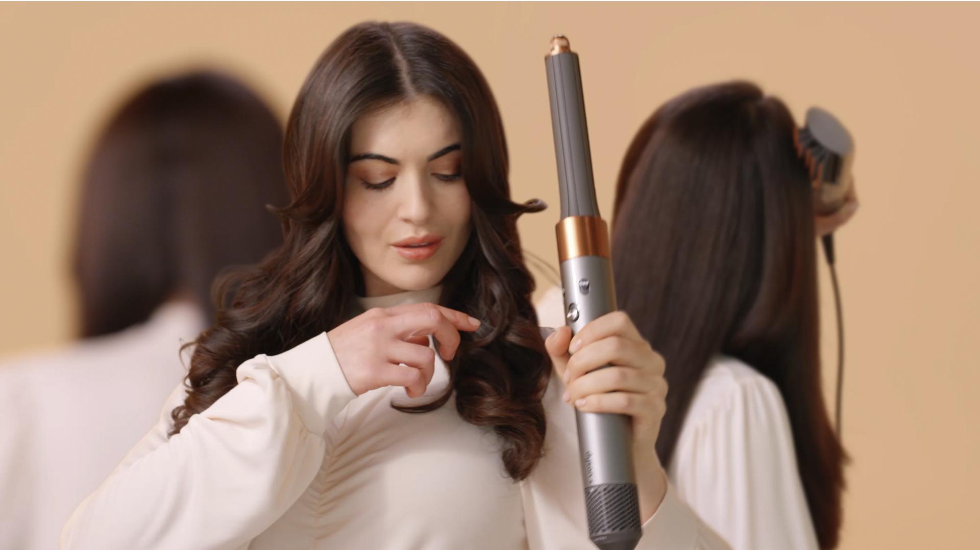 A young woman duplicated three times styling her hair with the Dyson Airwrap multi-styler